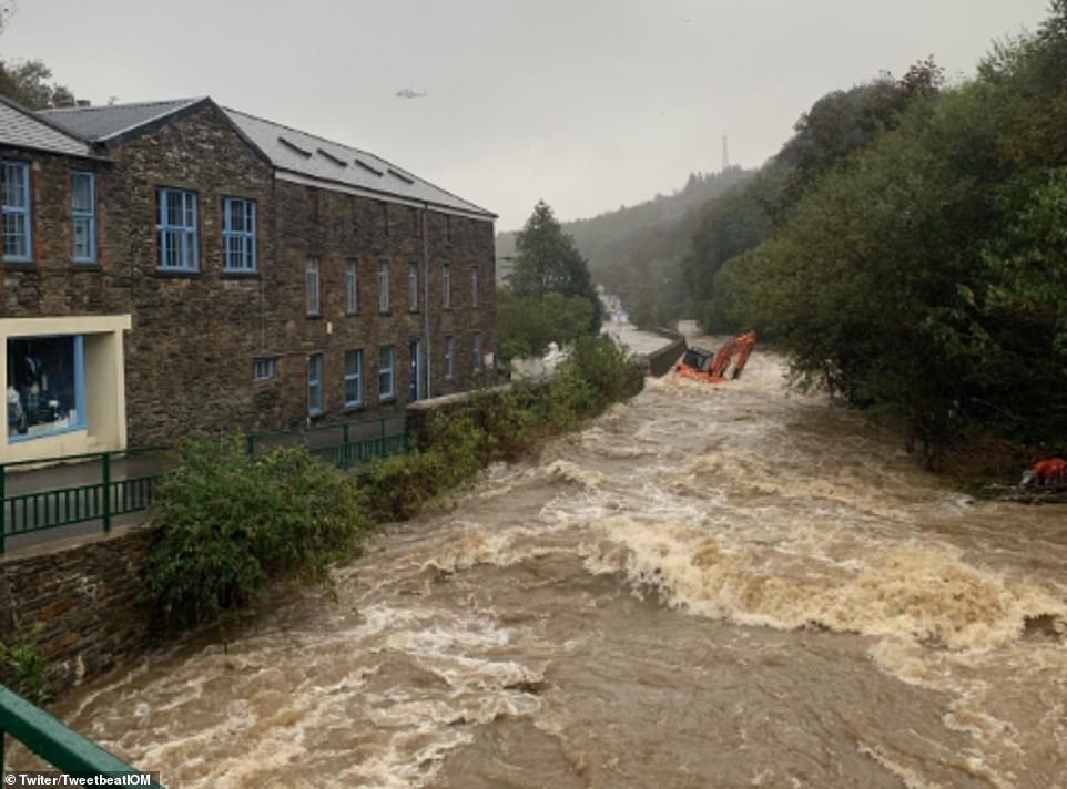 A digger has been washed into a river in the Isle of Man today following heavy rain on the island in recent days